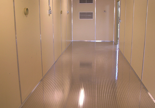a brown storage container with a shiny special flooring, it has a door with a customized window in the door at the back. 